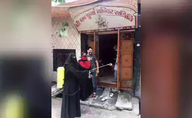 ഡല്‍ഹിയിലെ ക്ഷേത്രങ്ങള്‍ അണുവിമുക്തമാക്കി ബുര്‍ഖാ ധരിച്ച മുസ്‌ലിം യുവതി; സ്വാഗതം ചെയ്ത് ക്ഷേത്ര പൂജാരിമാര്‍