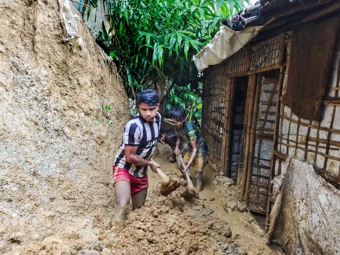 കനത്ത മഴയെതുടര്ന്ന് തങ്ങളുടെ പാര്പ്പിട കേന്ദ്രത്തിലേക്ക് ഒലിച്ചിറങ്ങിയ മണ്ണ് നീക്കം ചെയ്യുന്ന അഭയാര്ഥി യുവാക്കള്