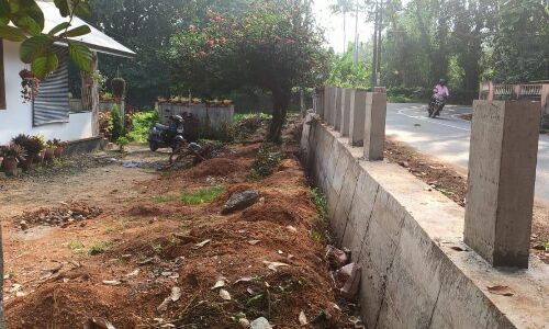 റോഡിന്റെ പാര്‍ശ്വഭിത്തി ഉയര്‍ത്തി കെട്ടിയതു മൂലം വിട്ടിലേക്ക് ഇറങ്ങാന്‍ കഴിയാതെ കുടുംബം