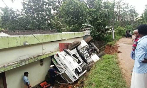 കോണ്ക്രീറ്റ് മിക്സിങ് ലോറി വീടിന് മുകളിലേക്ക് മറിഞ്ഞു കോണ്ക്രീറ്റ് മിക്സിങ് ലോറി വീടിന് മുകളിലേക്ക് മറിഞ്ഞു